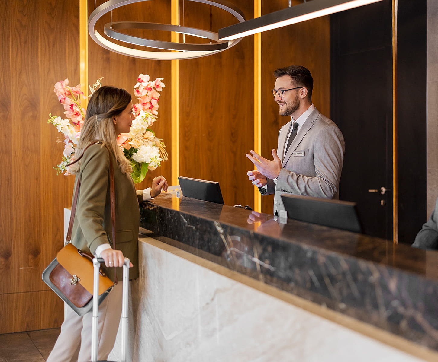 Couple exiting luxury car on city street.