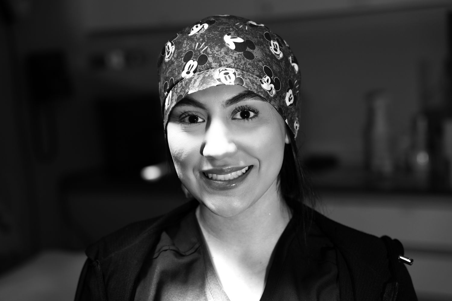 Smiling individual wearing a Mickey Mouse headscarf.