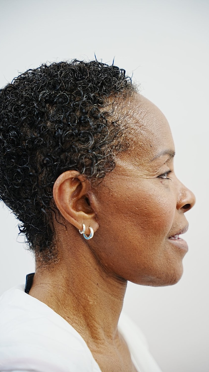 Profile of a woman with curly short hair.