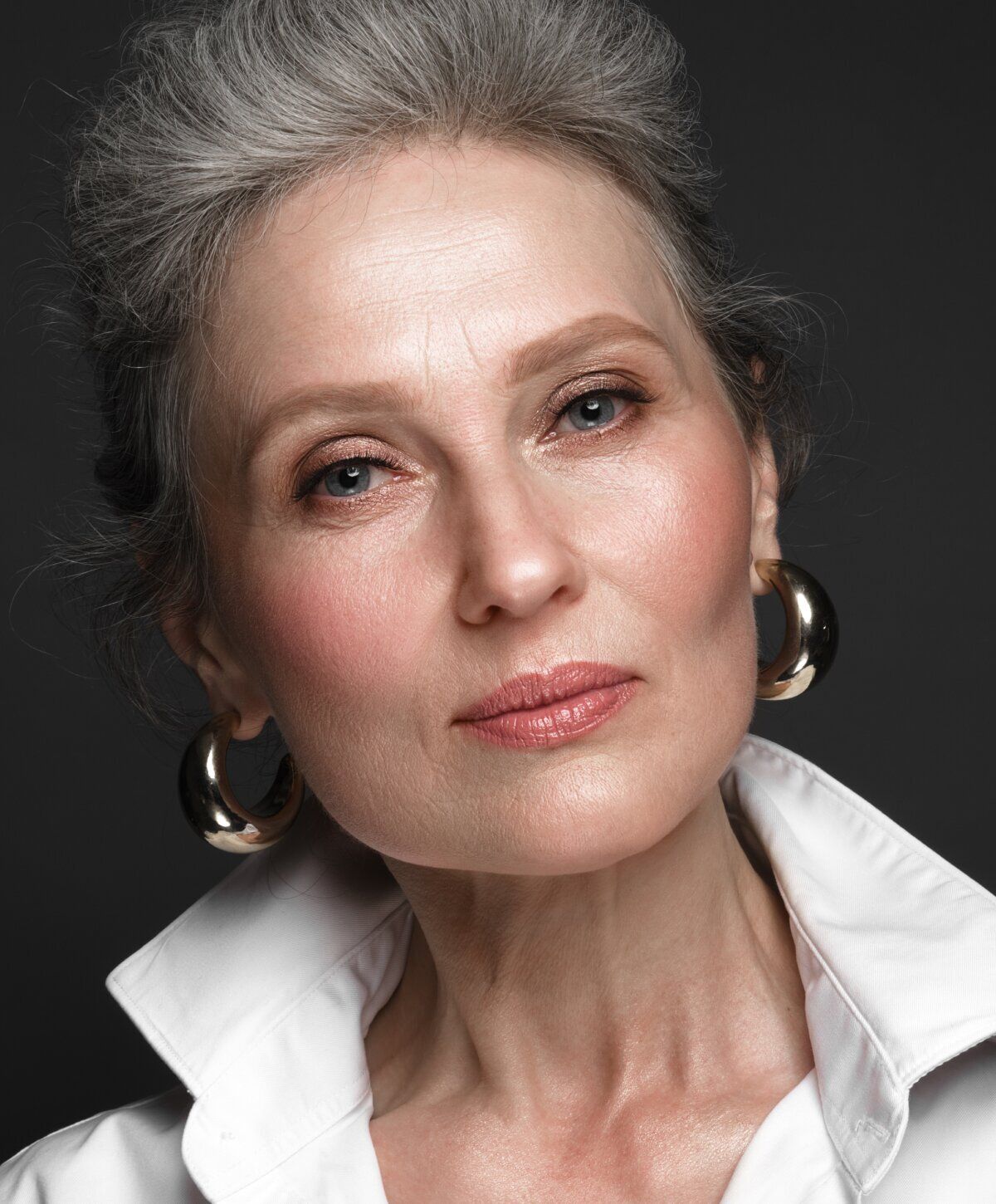 Portrait of an elegant older woman with earrings.