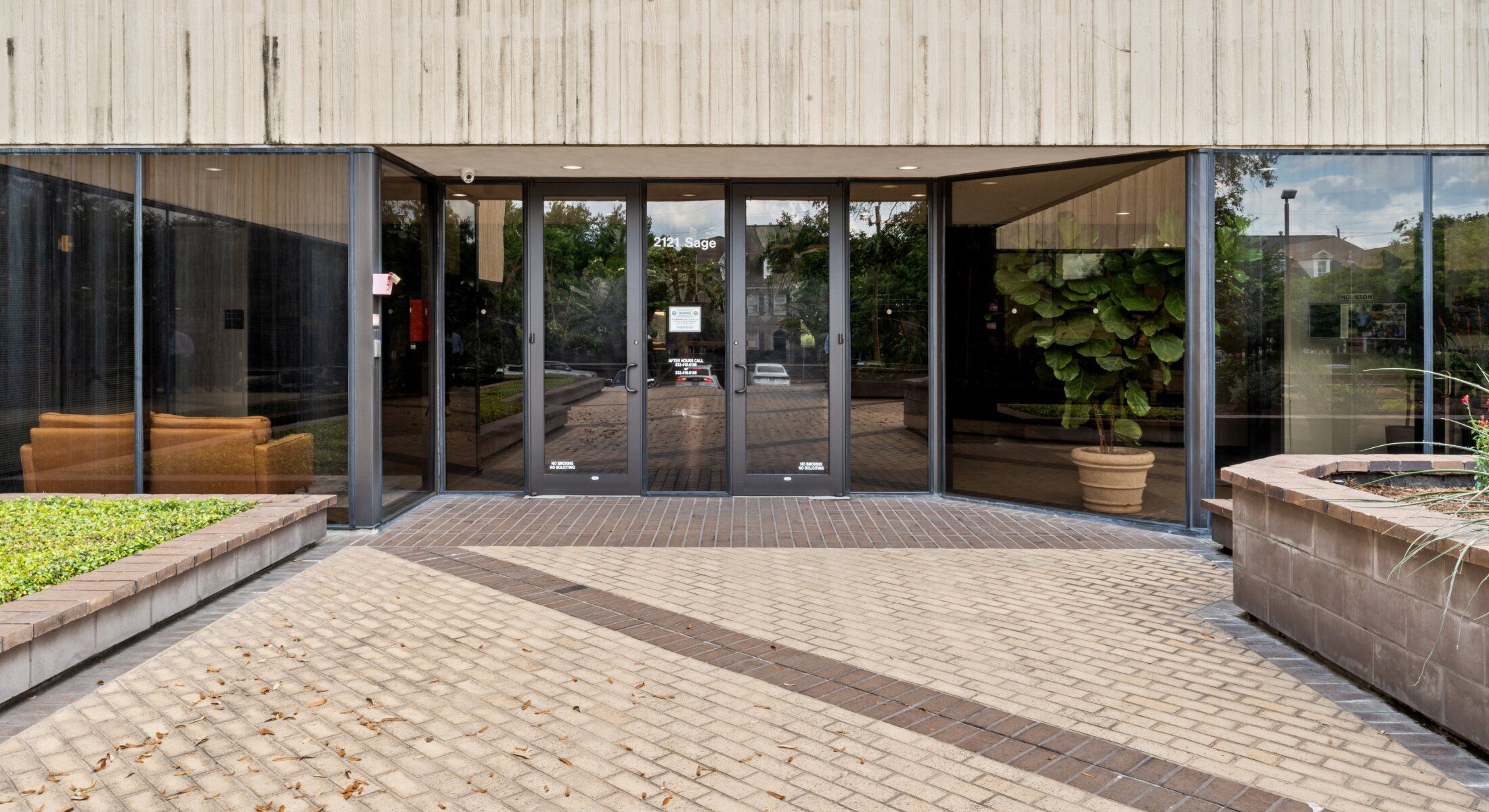 Entrance of a modern building with greenery.