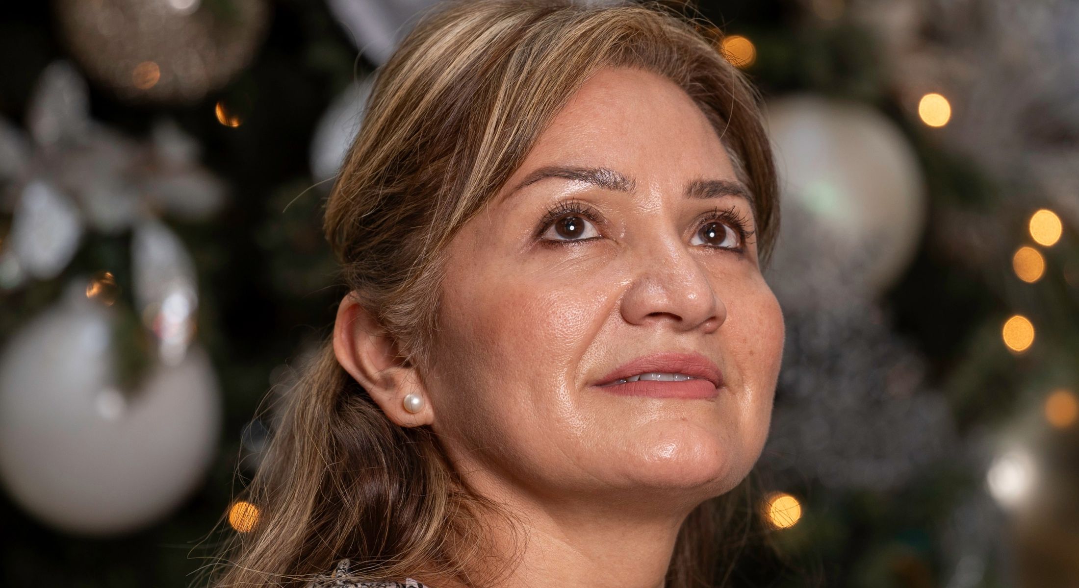 Smiling woman by a festive background.