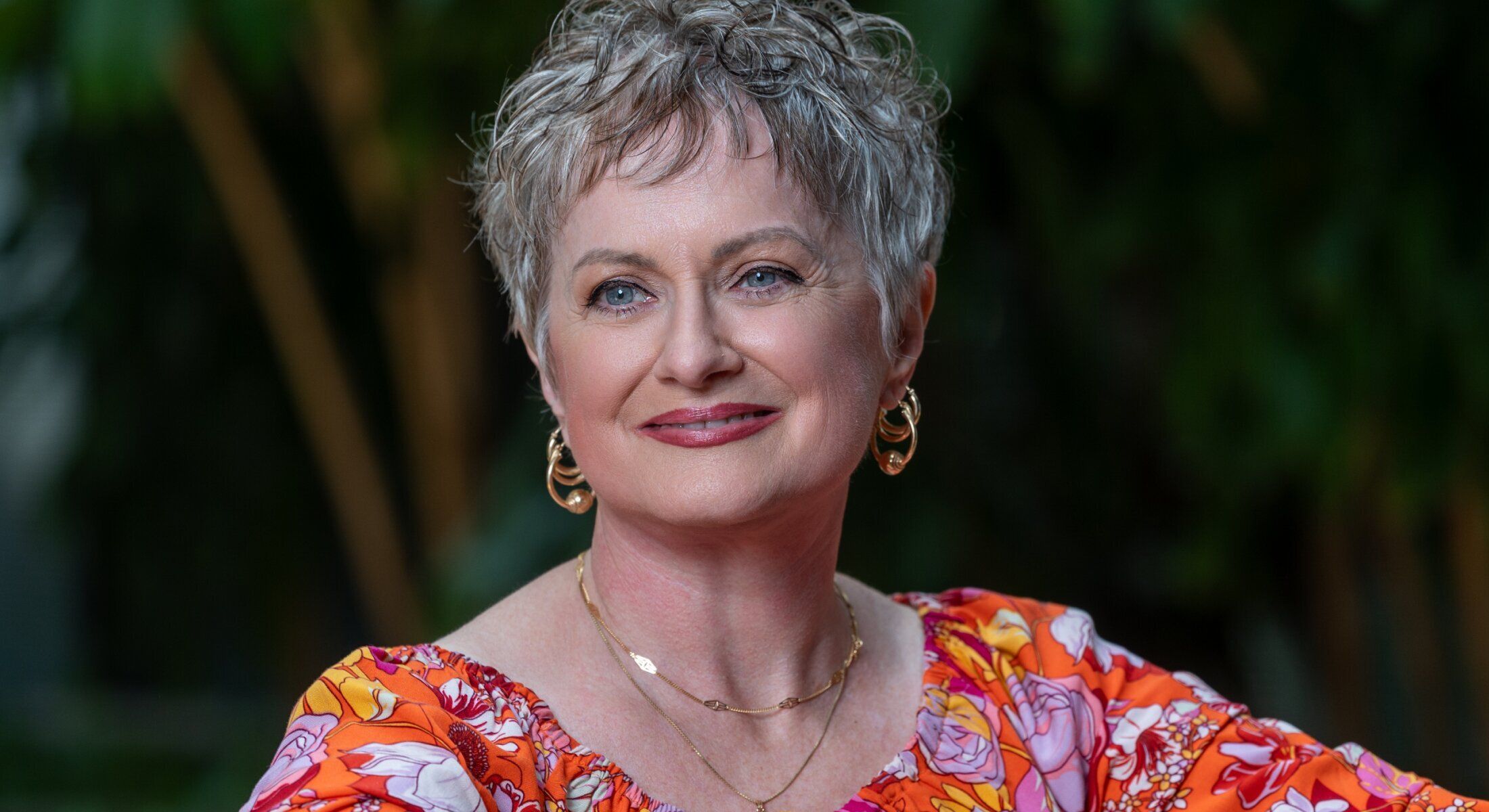 Woman wearing elegant jewelry with neutral background.