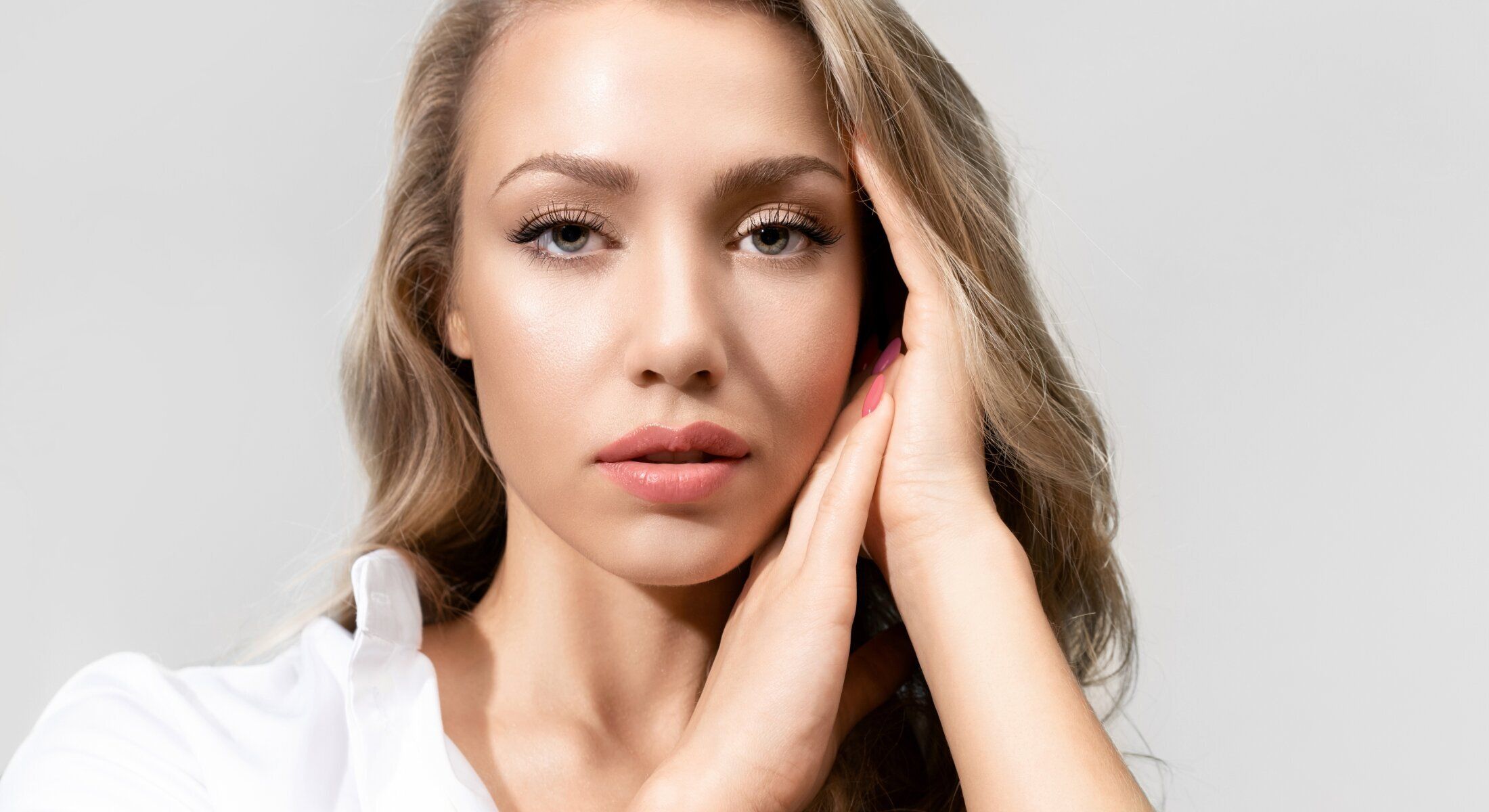 Woman with hands on face, natural beauty portrait.